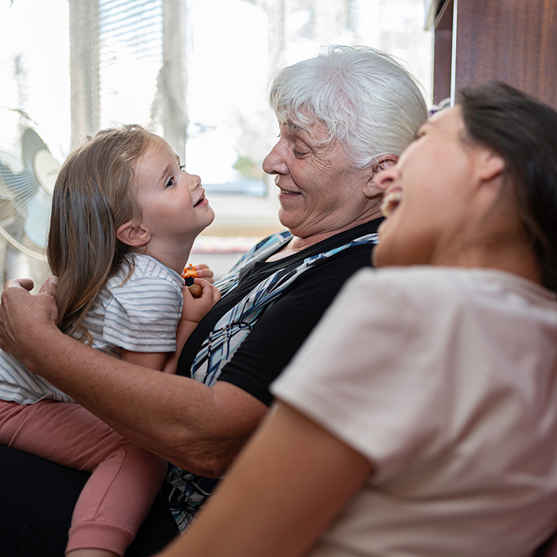 Three generations of family laughing together